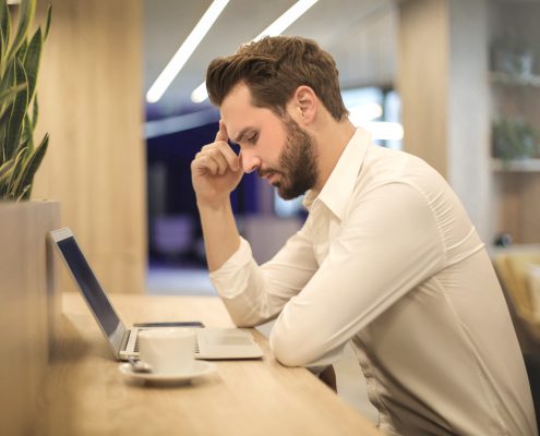 Man looking at a laptop and thinking about back office services